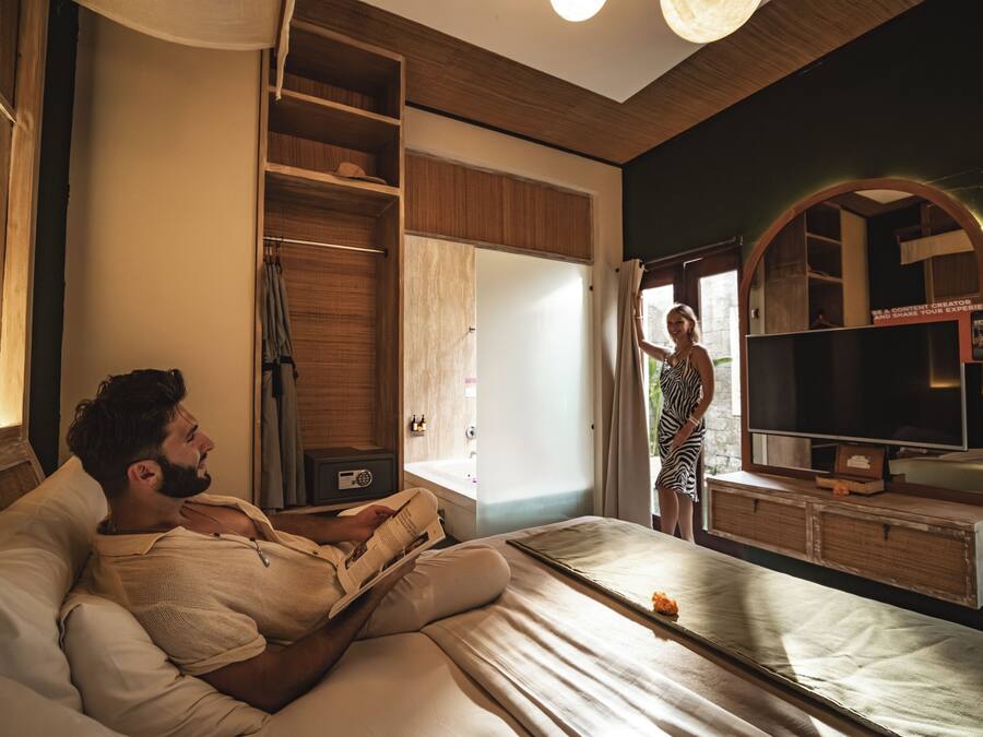 A bedroom with a bed, a television, and a wardrobe.