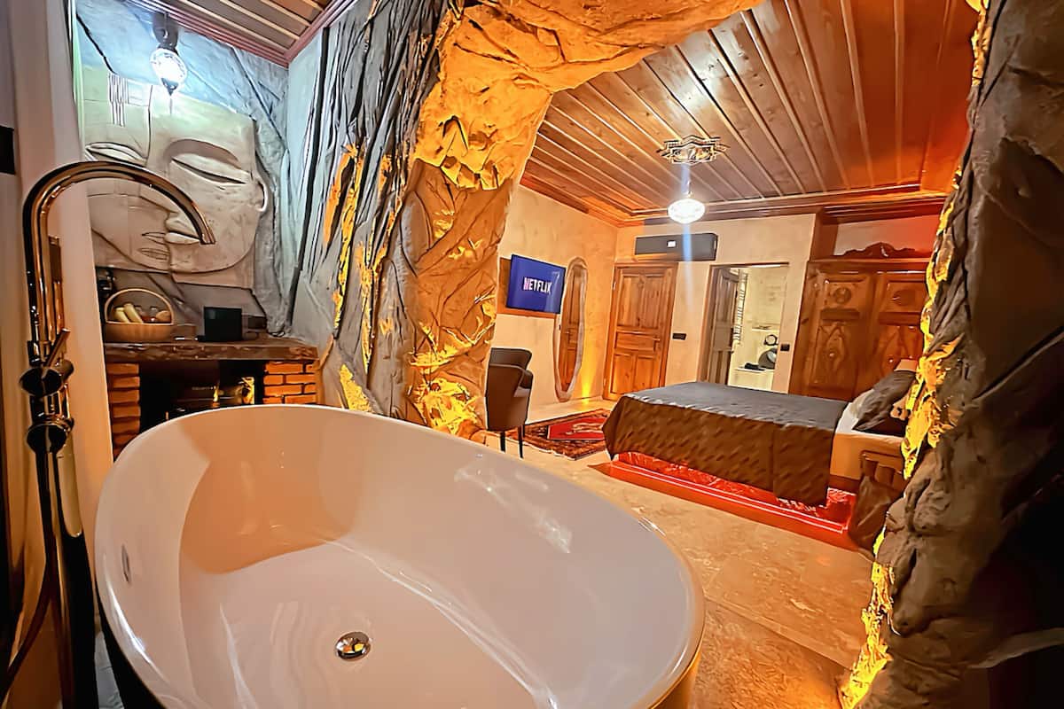 A modern bathroom with a freestanding bathtub, a mirror, and a wall-mounted sink.