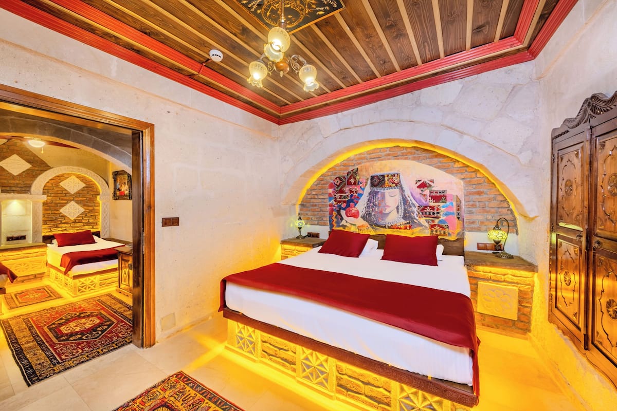 A bedroom with a large bed, wooden headboard, and a decorative wall arch.
