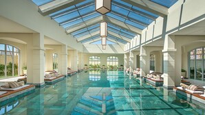 A large indoor swimming pool with multiple lounge areas and a glass ceiling. - FLC Luxury Resort Samson (Sam Son)