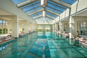 Una piscina al aire libre, sombrillas, sillones reclinables de piscina