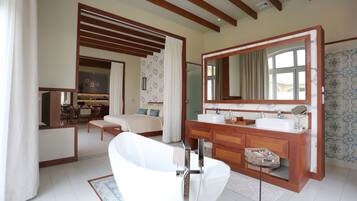 Un baño moderno con una bañera independiente, un espejo grande y un tocador de madera.