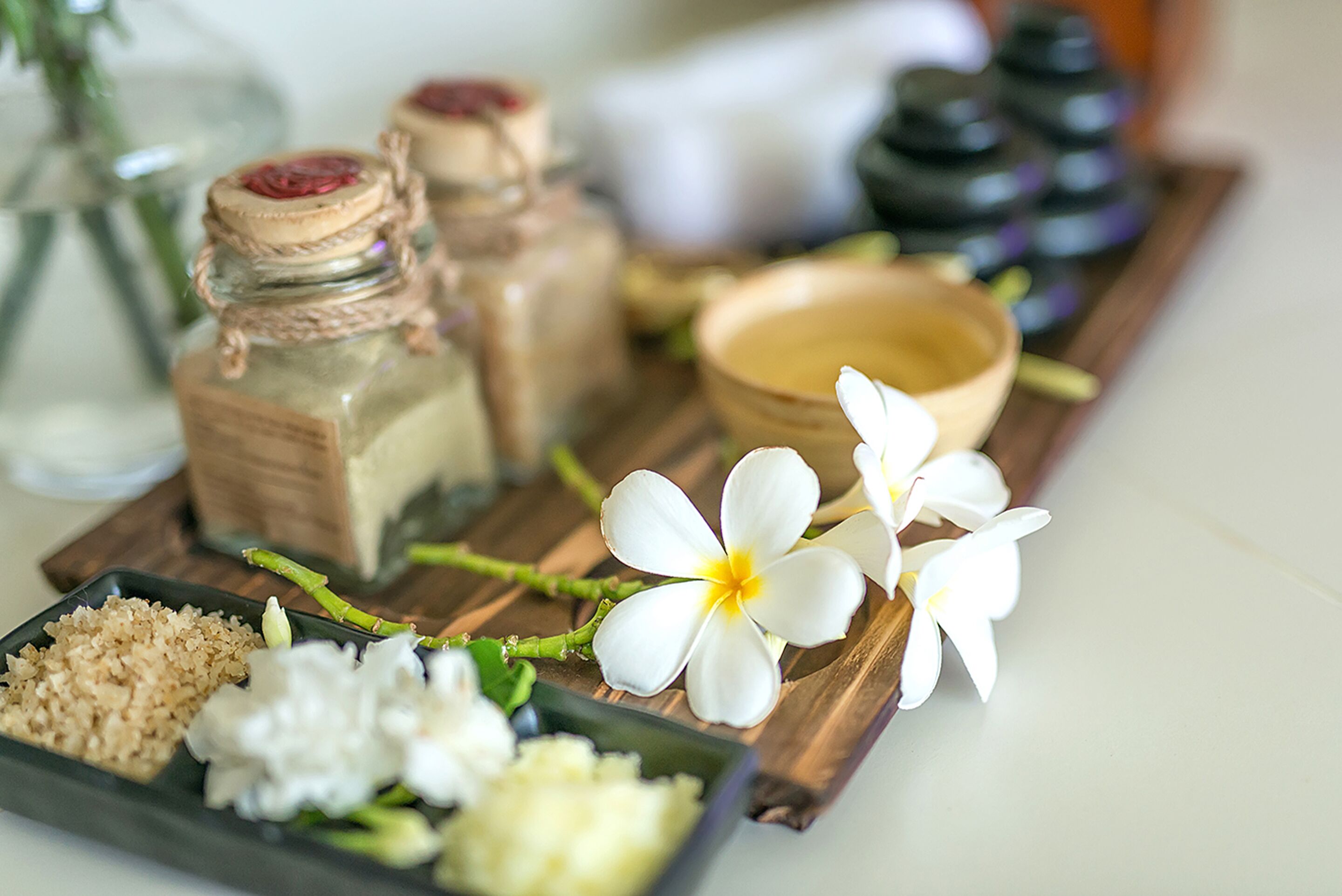 Un plateau en bois contenant divers objets, notamment un bol, des pots et des fleurs.