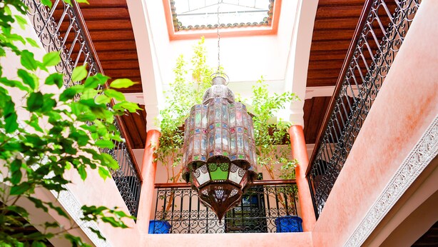 A staircase with ornate metal railings and a decorative lantern at the top.