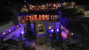 A two-story house with a visible entrance, a covered patio area, and a driveway.