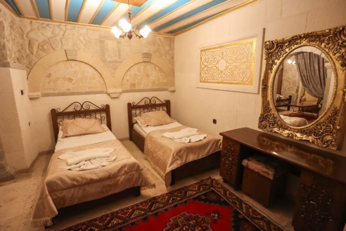 A room with two beds, a mirror, and a dresser.