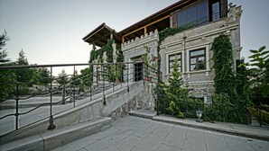 A stone building with a staircase leading to a balcony.