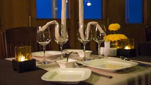 A dining table set with wine glasses, plates, and a candle. - L'Amant Cruise (Thoi Son)