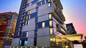 A multi-story hotel with a prominent "ASTON" sign at the top, featuring a modern glass facade and a covered entrance area. - Aston Priority Simatupang Hotel & Conference Center (Jakarta)