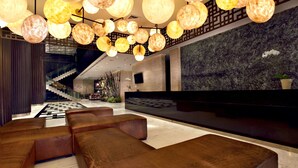 A modern lobby with a reception desk, seating area, and a staircase leading to upper floors. - Aston Priority Simatupang Hotel & Conference Center (Jakarta)