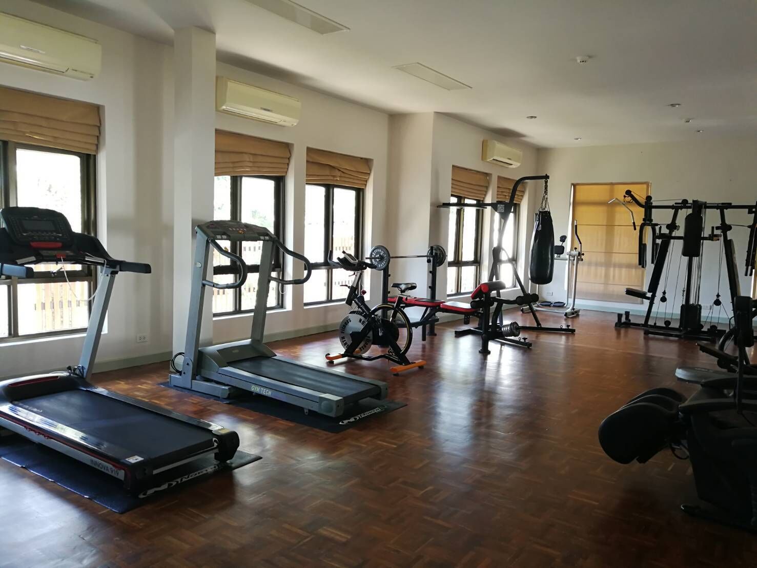 Un gimnasio amplio con cintas de correr, máquinas de pesas y un saco de boxeo.