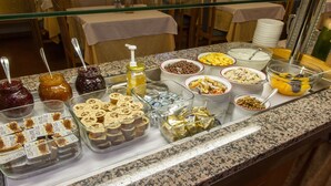 A buffet with various food items and condiments. - Hotel Lucia (Levico Terme)