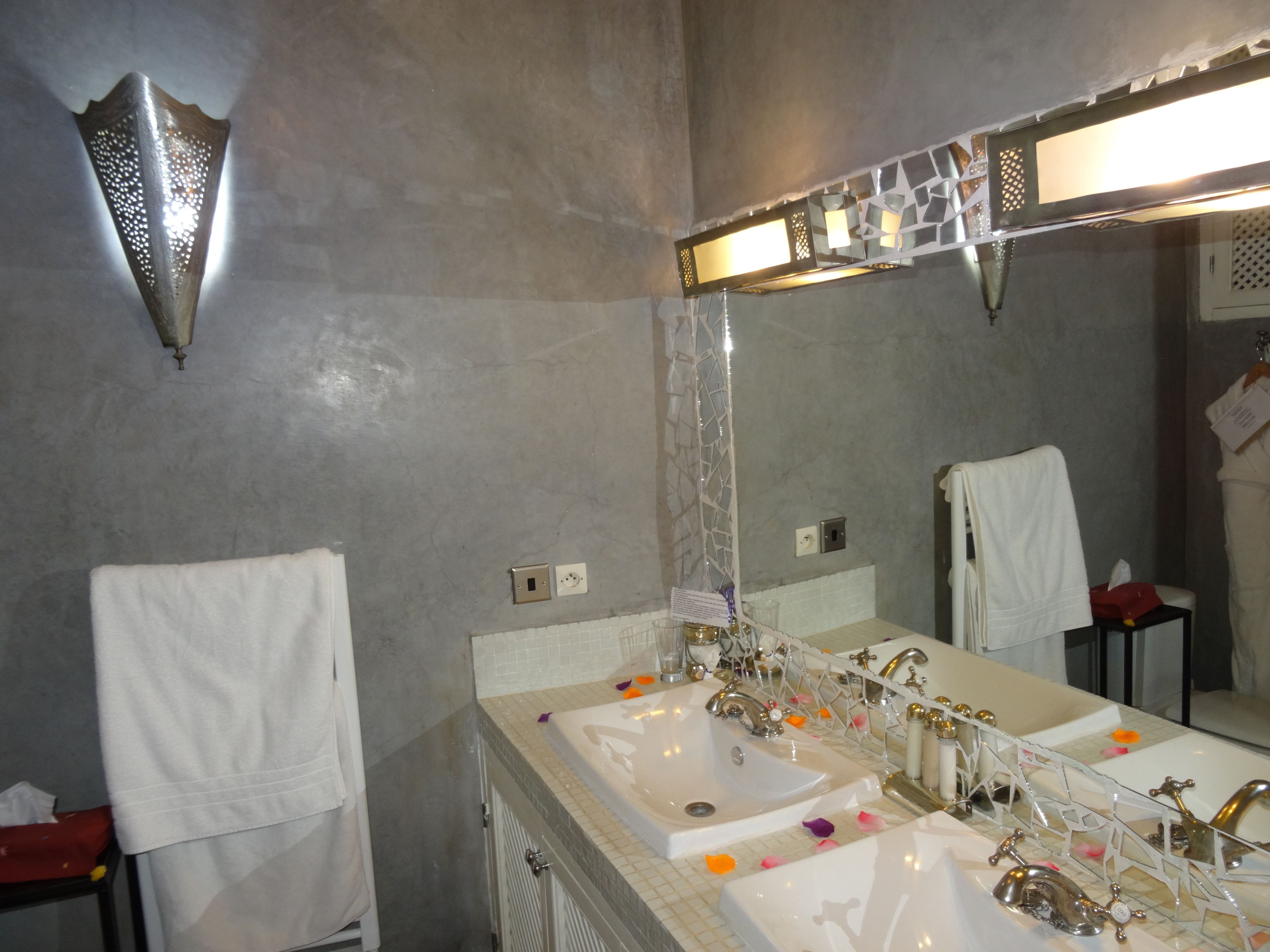 A bathroom with two sinks, a large mirror, and a shower.