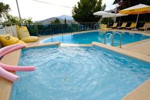 Piscina a l'aire lliure, para-sols i gandules