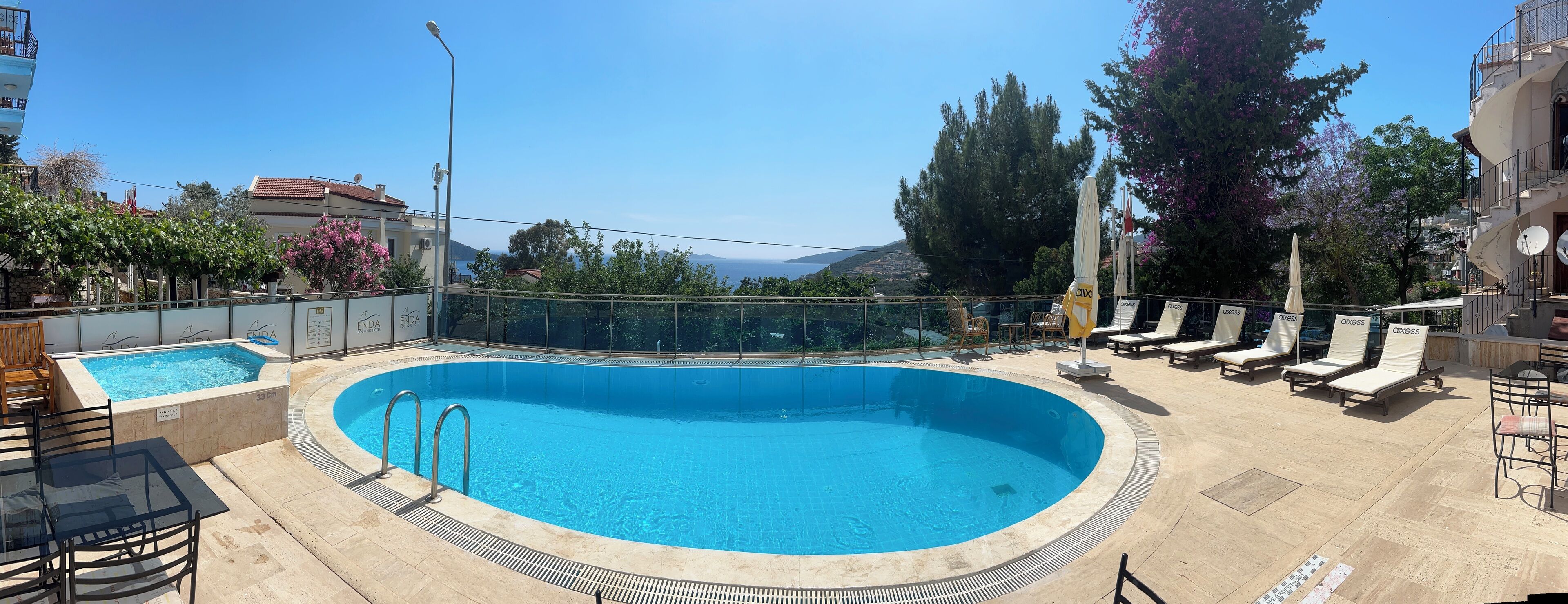 Een buitenzwembad, parasols voor strand/zwembad