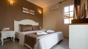 A bedroom with a bed, bedside tables, a dresser, and a window with curtains. - Enda Boutique Hotel (Kas)