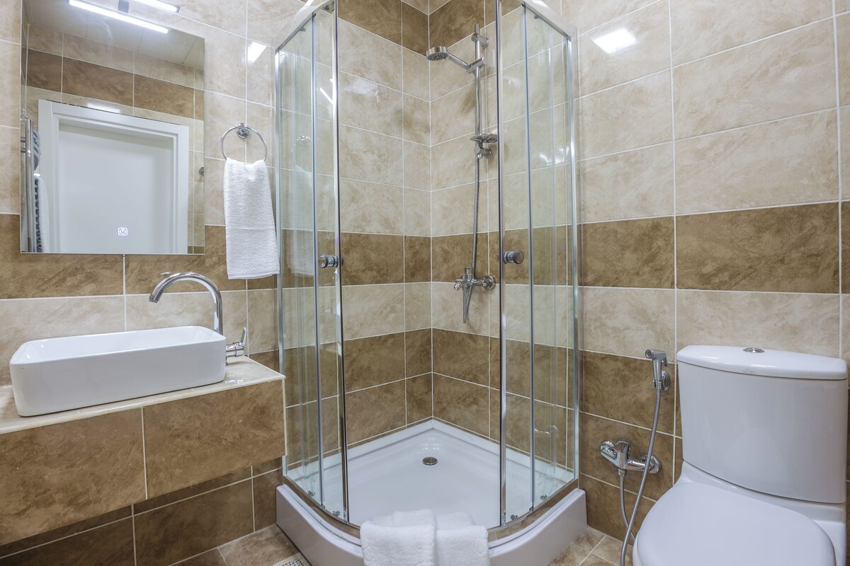 Une salle de bain avec une douche à parois de verre, un lavabo et des toilettes.