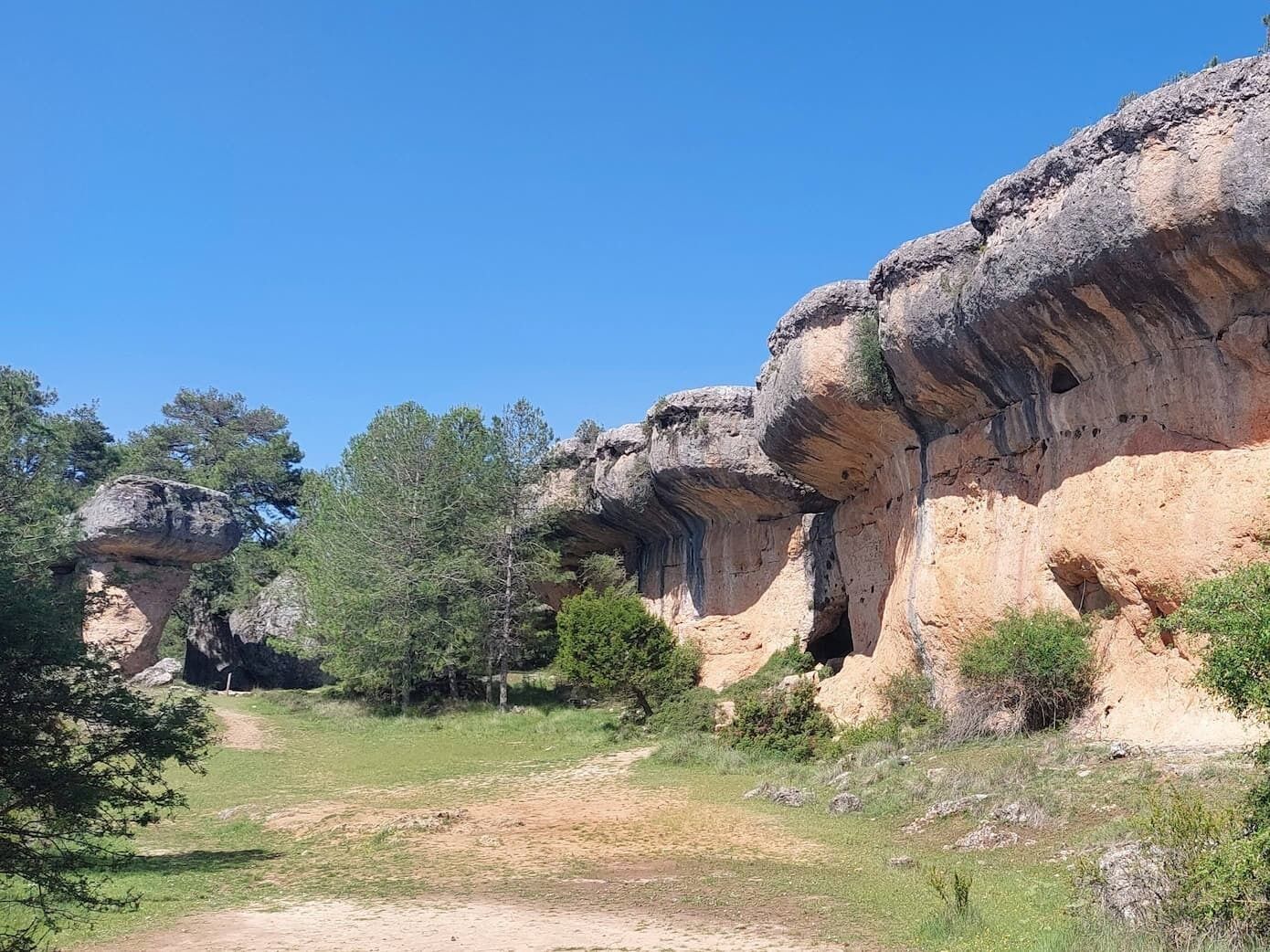 Un paisaje natural con formaciones rocosas y un camino de tierra.