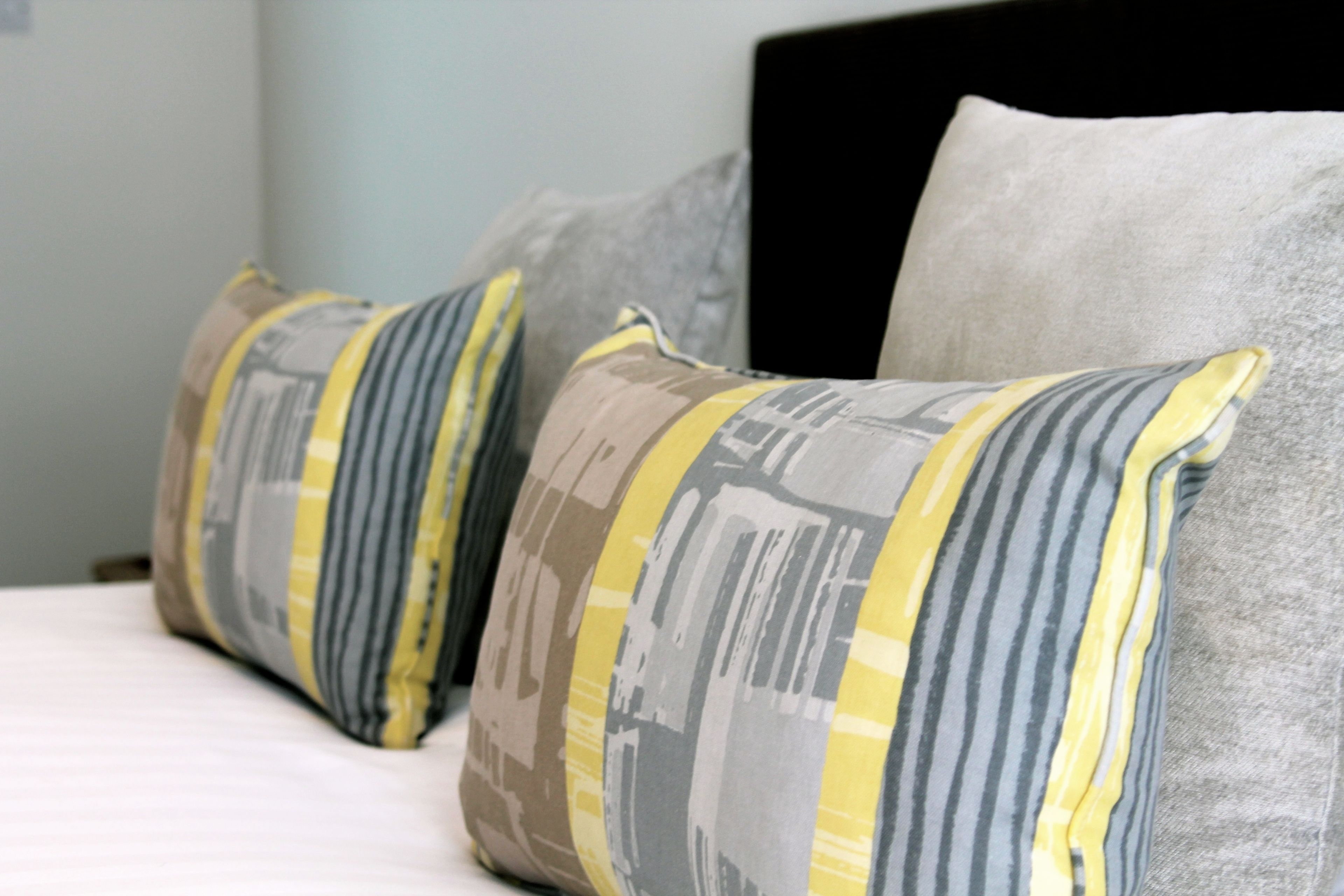 A bed with two pillows featuring a striped pattern.