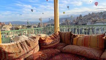 A balcony with a view of a cityscape and hot air balloons.