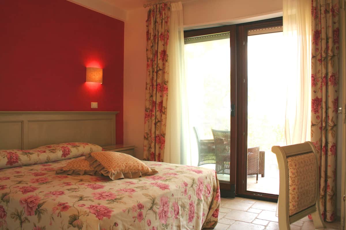 Una habitación con una cama, una silla y vistas al exterior.
