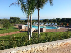 A pool area with lounge chairs and a view of the ocean. - B&B La Vigna (Carovigno)