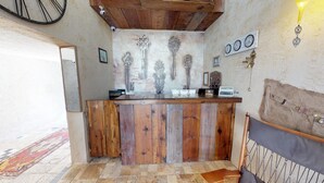 A rustic interior with a wooden bar, vintage clocks, and a patterned wall. - Patron Hotel (Antalya)