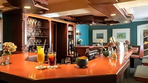 Eine Bar mit einer polierten Holztheke, Gläsern und Flaschen.