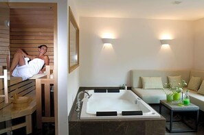 Ein modernes Badezimmer mit einer großen Badewanne, einer Holzbank und einer Couch mit Kissen.