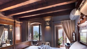 A bedroom with a large bed, wooden beams, a window with a view, a bedside table, and a mirror. - Boutique Hotel Villa dei Campi (Gavardo)