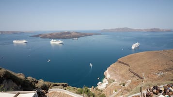 A coastal area with a ferry terminal, boats, and a mountainous landscape.