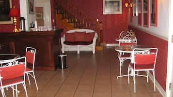 Ein Essbereich mit roten und weißen Möbeln, einer Treppe und einer Bar.