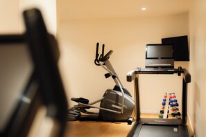 A treadmill with a digital display and a television mounted on a stand. - 9Hotel Republique (Paris)