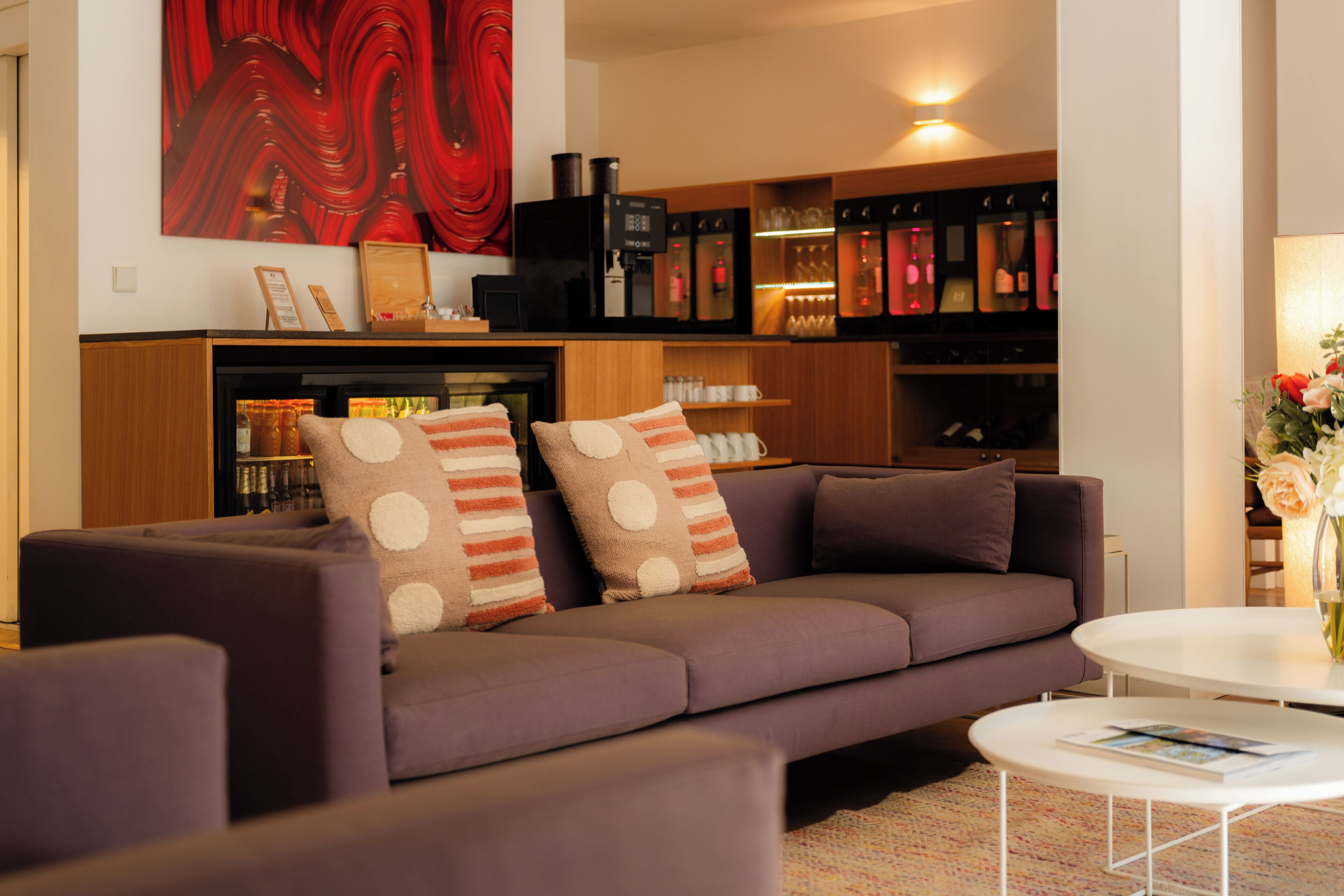 A modern living room with a sofa, armchairs, a coffee table, and a bookshelf.