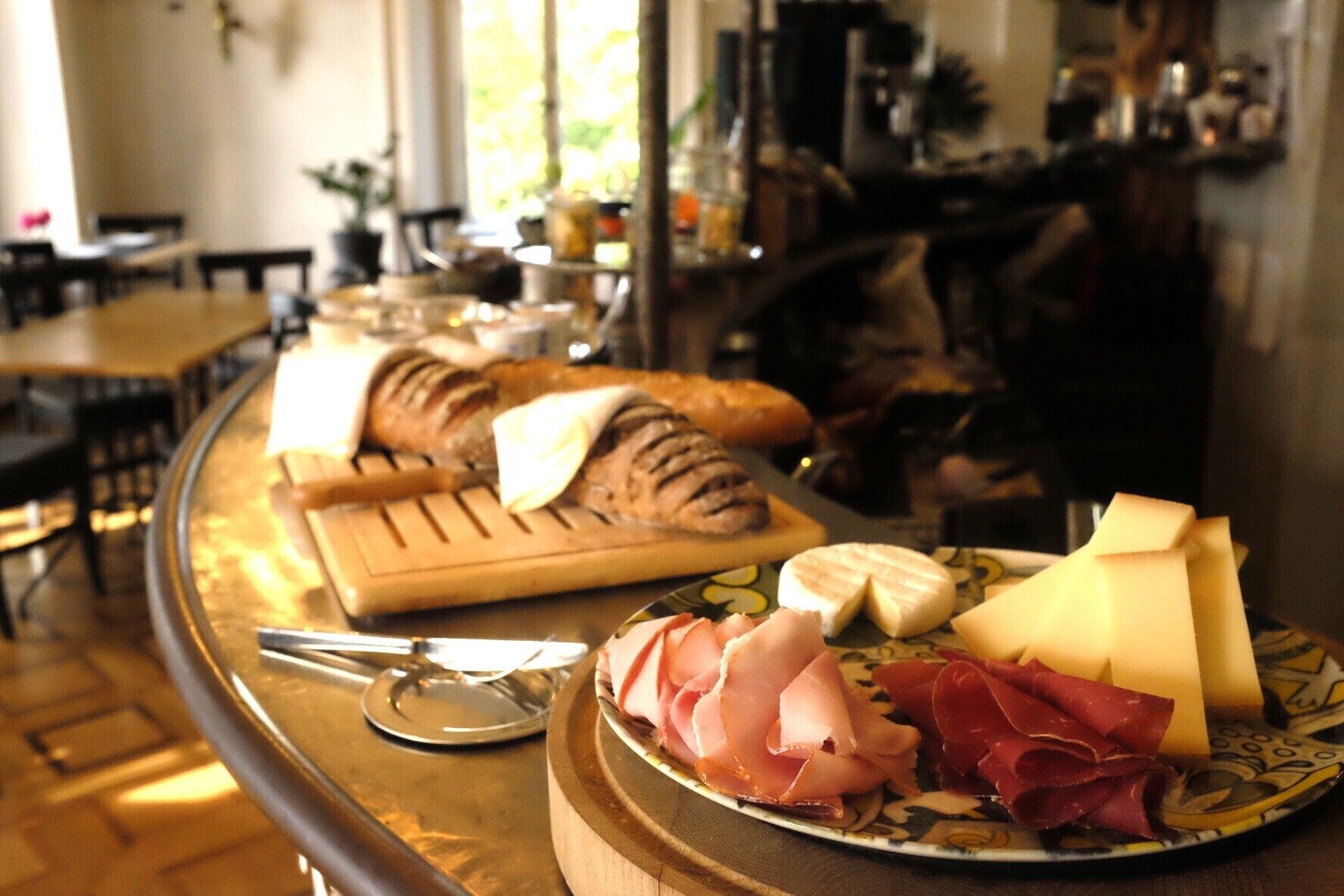 A breakfast buffet with bread, cheese, and ham.