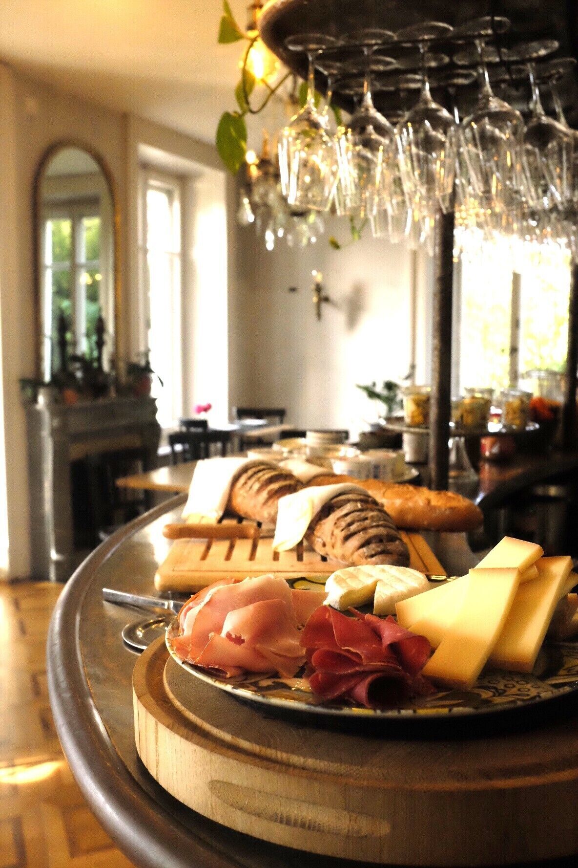 A cheese and charcuterie board with a wine glass holder above.