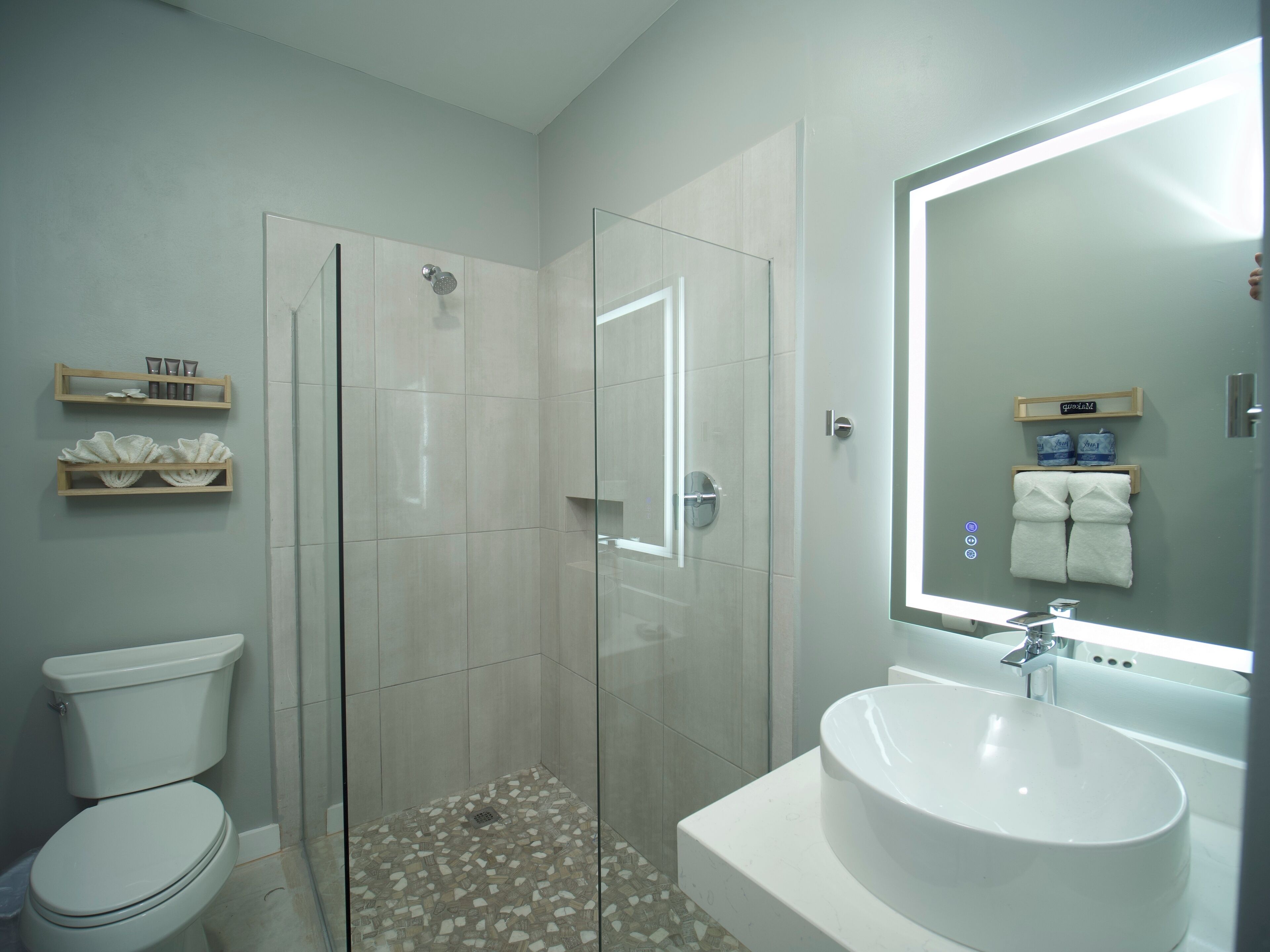A modern bathroom with a toilet, shower, and sink.