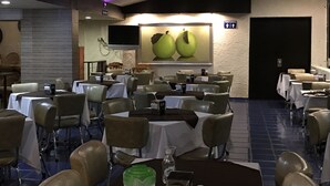 A conference room with tables and chairs, a ceiling fan, and a large painting of apples on the wall. - Hotel Plaza Centro (Tepatitlan de Morelos)