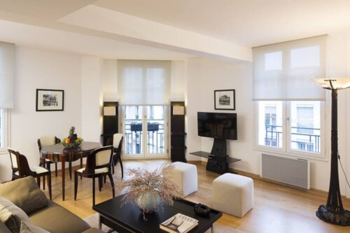Una sala de estar moderna con comedor, chimenea y ventanas amplias.