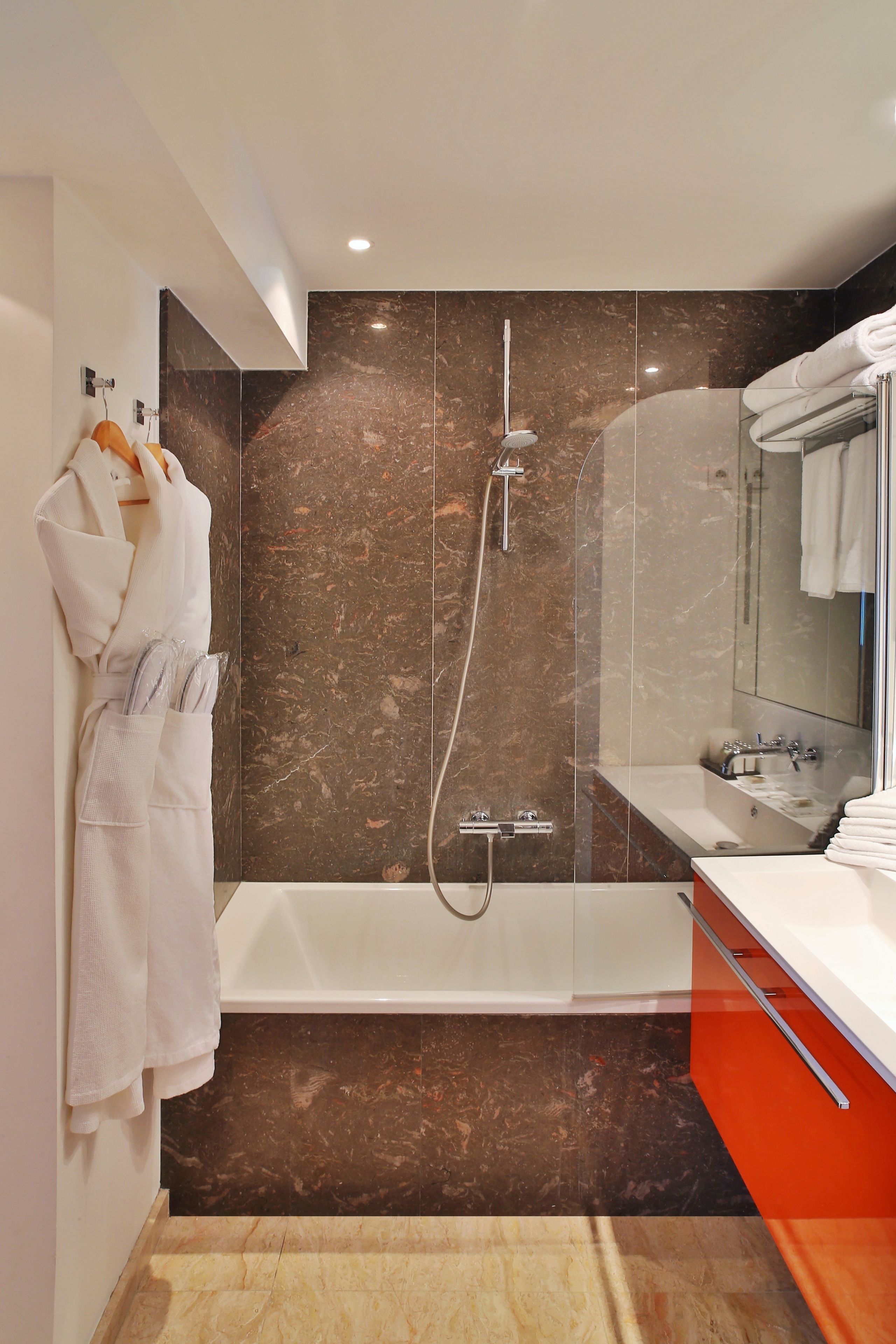 A modern bathroom with a large bathtub, a shower, and a vanity with a mirror.