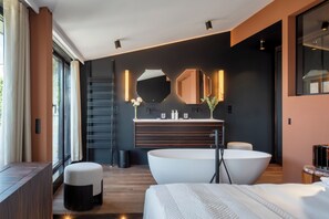 A modern bathroom with a large bathtub, a vanity with a mirror, and a window with curtains.