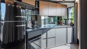 Eine moderne Küche mit einem integrierten Kühlschrank, einer Kaffeemaschine und einem Spülbecken.