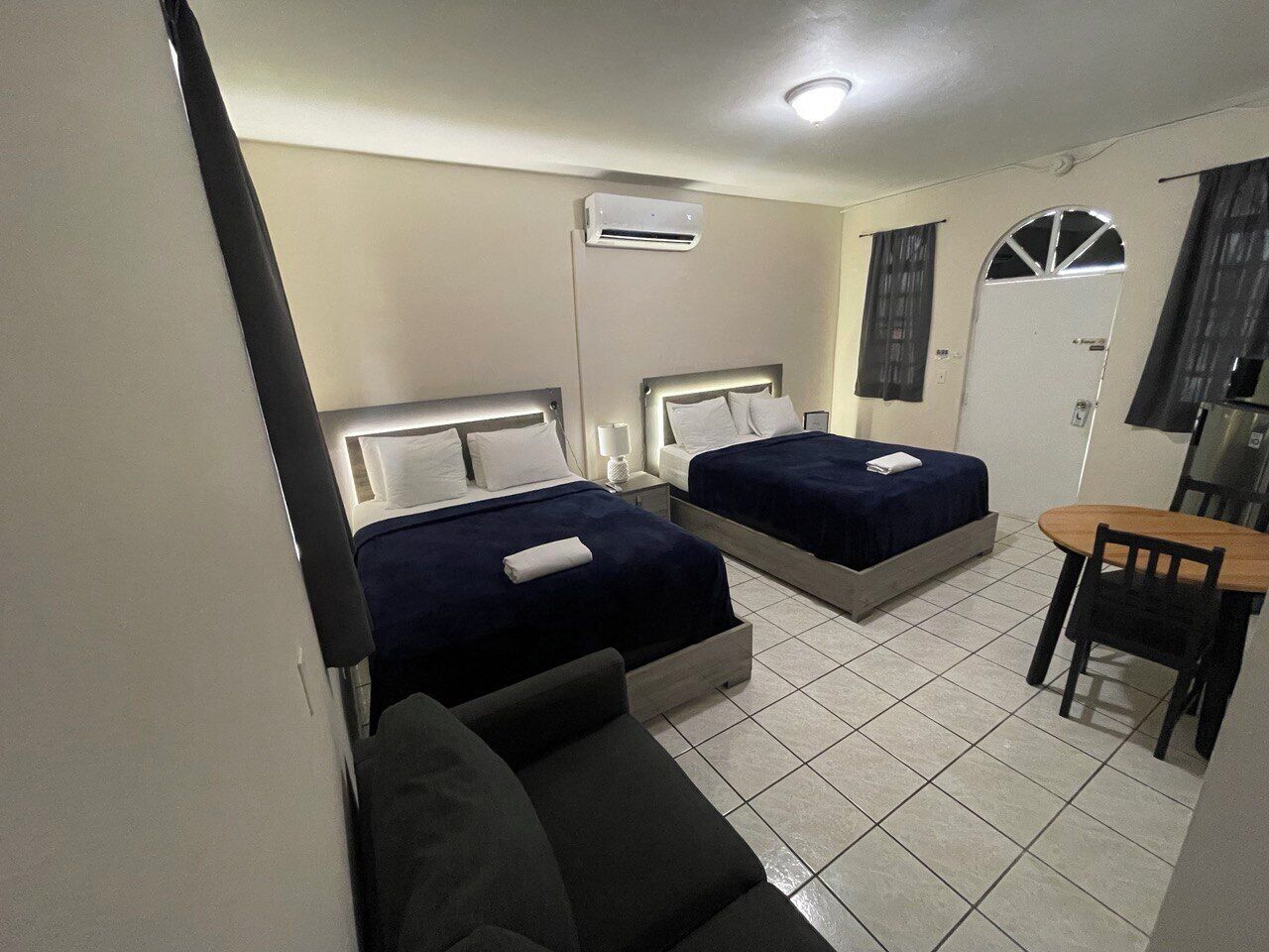 Een hotelkamer met twee bedden, een kleine tafel en een stoel.