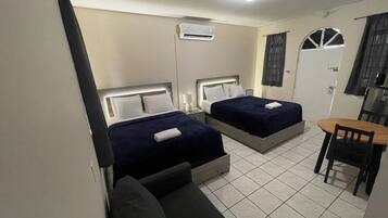 Een hotelkamer met twee bedden, een kleine tafel en een stoel.