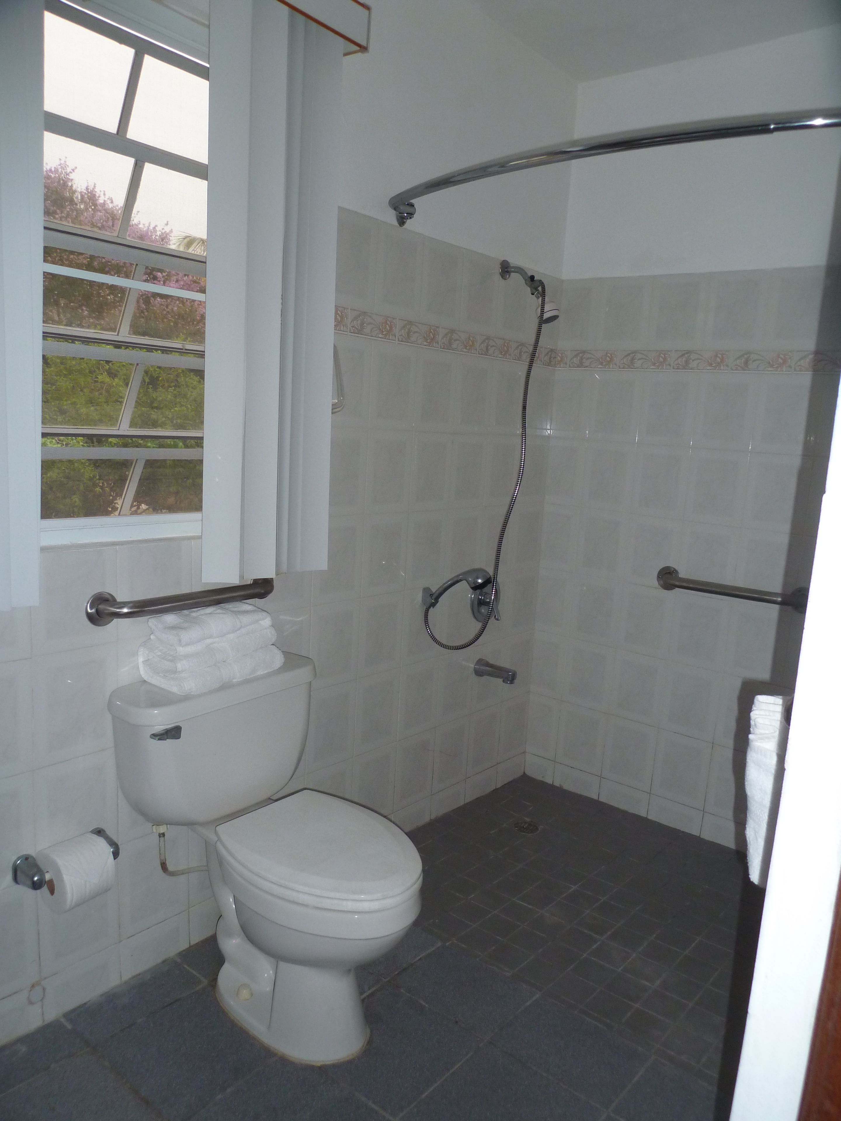 Ein Badezimmer mit Toilette, Dusche und Fenster.