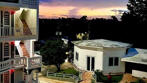 A multi-story building with a balcony and a staircase. - The Village Inn Hotel (Carolina)