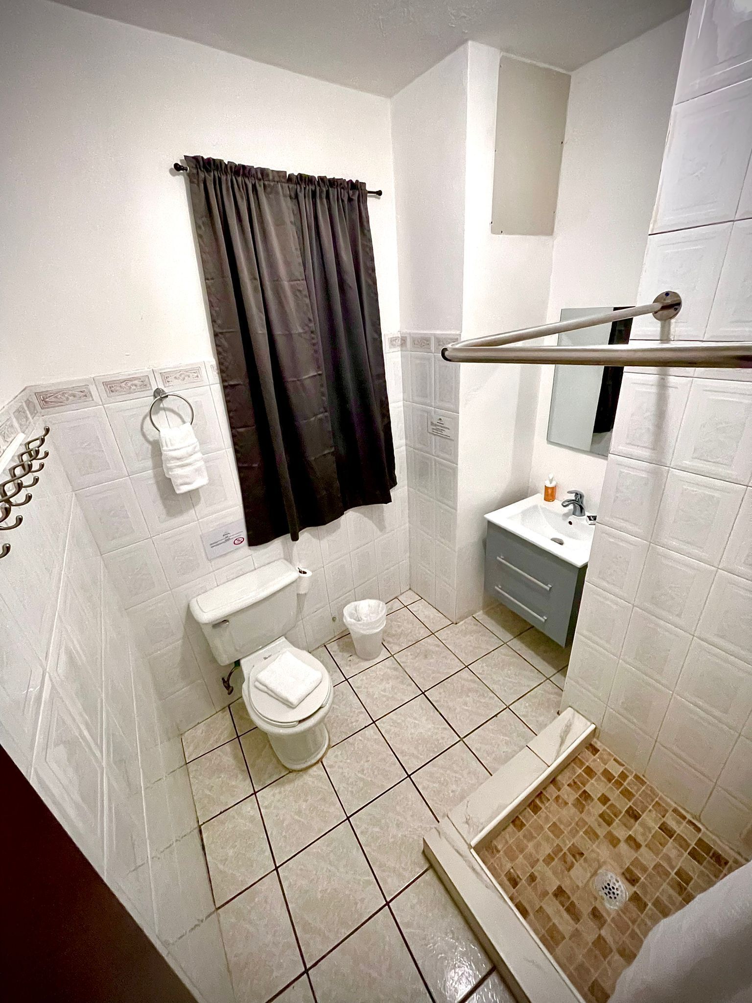 Een badkamer met toilet, bidet, wastafel en een douchegedeelte.