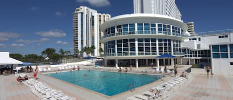 Una piscina al aire libre, sillones reclinables de piscina