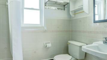Un baño con inodoro, lavabo y toallero.
