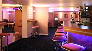 A bar area with stools, a counter, and a sound system. - Dutchman Hotel (Blackpool)